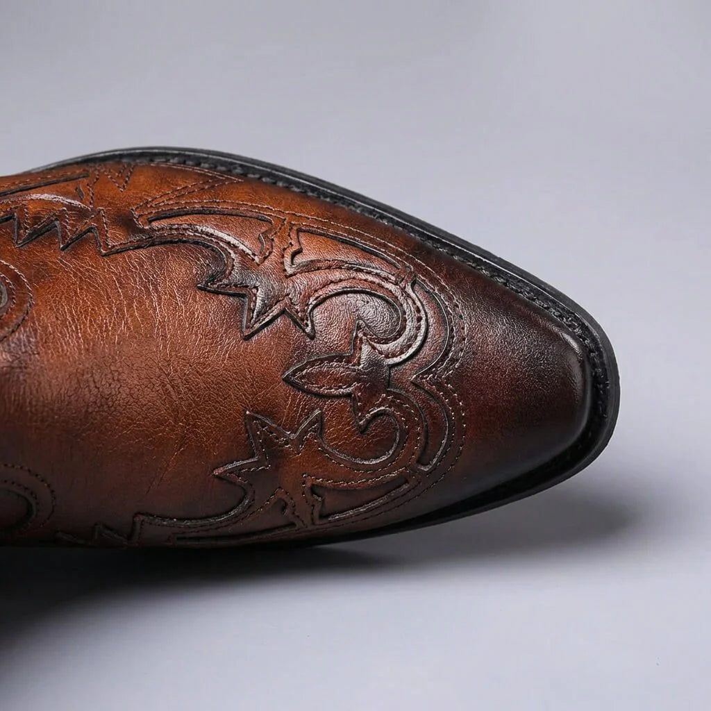 Pointed toe of cognac brown Western Chelsea boots with tooled overlay, top view