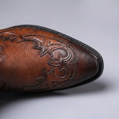 Pointed toe of cognac brown Western Chelsea boots with tooled overlay, top view