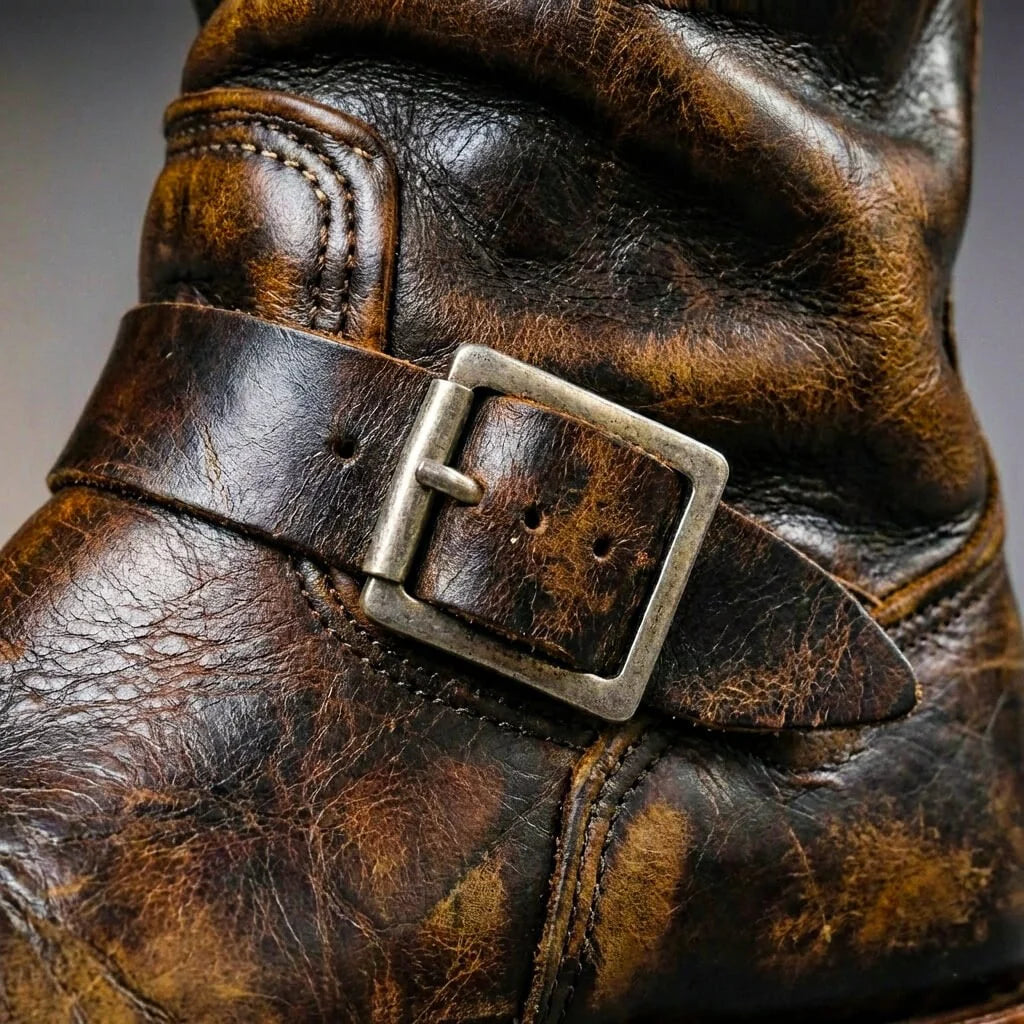Close up of the instep buckle strap on brown distressed leather engineer boots