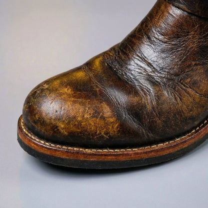 Rounded toe and welted sole of brown distressed leather engineer boots, close up